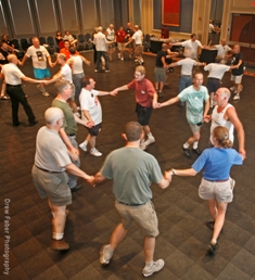 Square dancers holding hands in a large circle