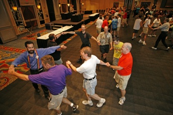 Square dancers joining hands across a ballroom floor